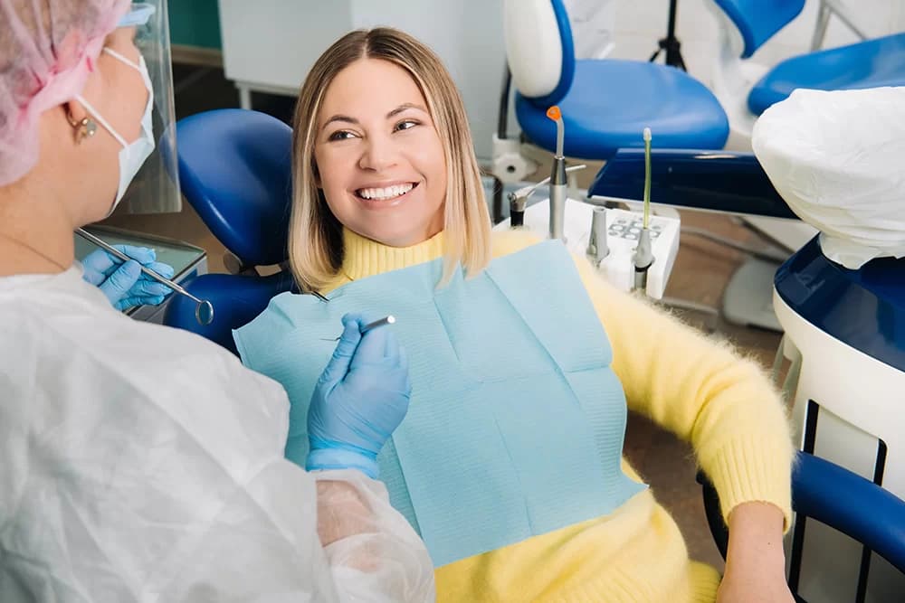Niña sonríe y se mira en el dentista